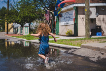 a girl running through a puddle 