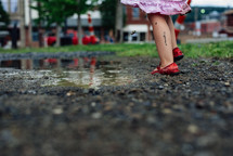 feet of a little girl standing in a puddle 