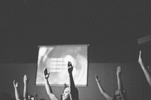 Hands raised in worship at a worship service. 