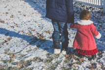 brother and sister walking holding hands in the snow 