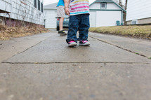 Children standing on a sidewalk