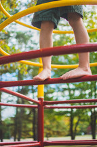feet of a toddler boy on playground equipment 