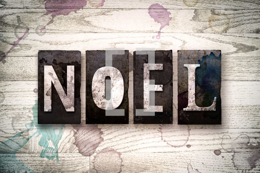 word noel on a white wash wood background 