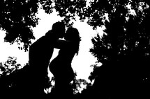 silhouette of a man and pregnant woman kissing 