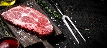 Raw pork steak on a stone board. On a black background. High quality photo