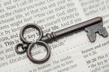 key lying on the pages of a Bible