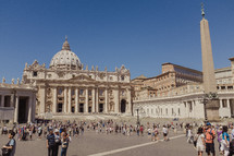 tourists in the colonnade and piazza of st peter's basilica