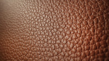 Extreme macro genuine brown leather background, high quality grained texture. Soft pattern surface of luxury bag. Animal skin material, handmade fashion accessories.