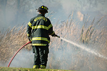 firefighter putting out a brush fire 