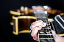 Hands holding a guitar.
