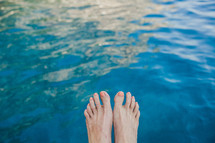feet hanging over water in Italy 