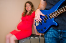 pregnant woman and a man with an electric guitar 