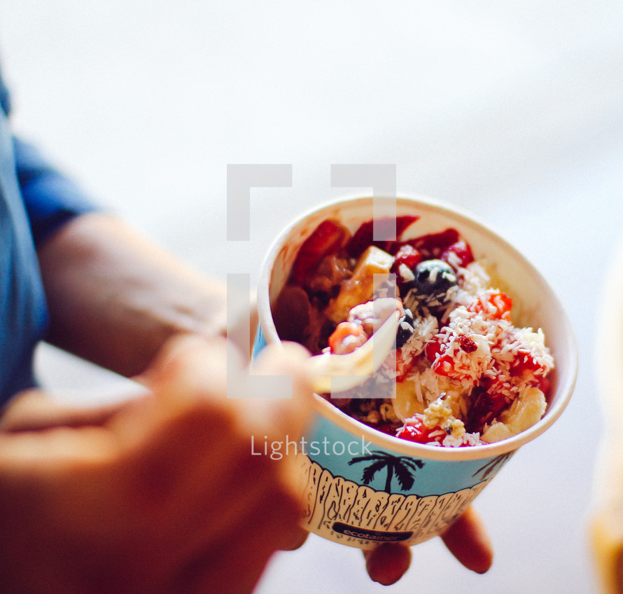 a man eating frozen yogurt with berries 