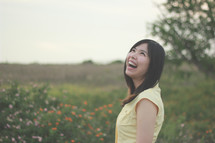 a young woman laughing outdoors 
