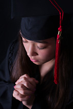 face of a female graduate in prayer