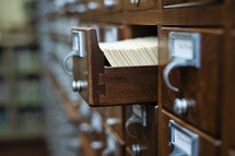 Library card catalog cabinet with an open drawer.