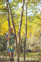 boy child with a walking stick in a forest 