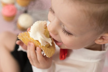 a toddler eating a cupcake 