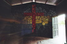 cross mosaic on a wall and open door 