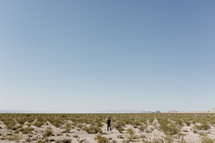 a man walking on a desert landscape in Nevada 