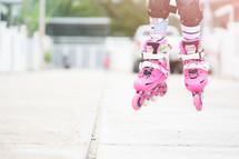 a little girl roller blading with knee pads 