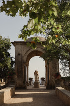 statue under a stone pergola in Italy 