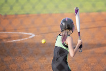a girl swinging a bat 