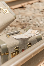 tickets and luggage on railroad tracks 