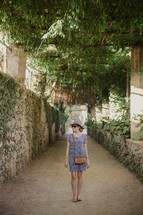 a woman walking on a narrow dirt street in Italy 