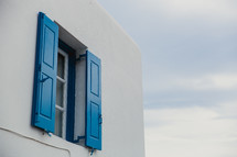 blue shutters on a white house in Greece 