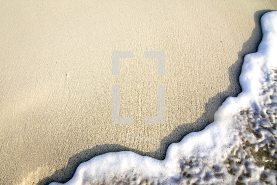 sea foam on a sand on a beach 