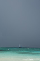 distant sailboat over turquoise blue water
