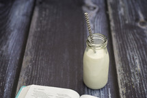 milk in a glass bottle and edge of a Bible 