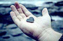 man holding a heart shaped rock