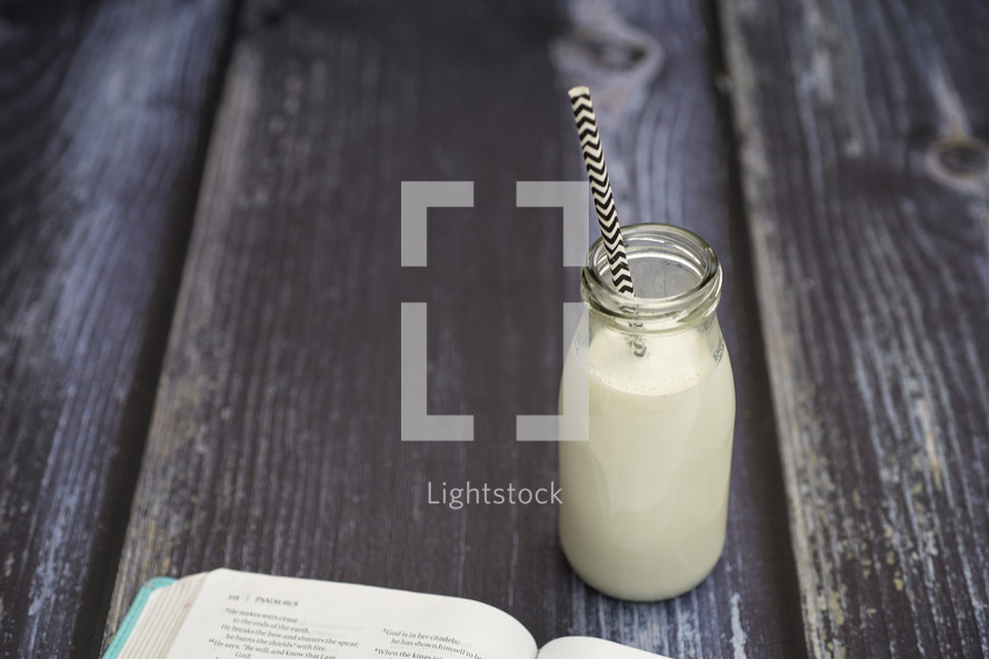 milk in a glass bottle and edge of a Bible 