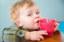 toddler boy drinking out of a straw 