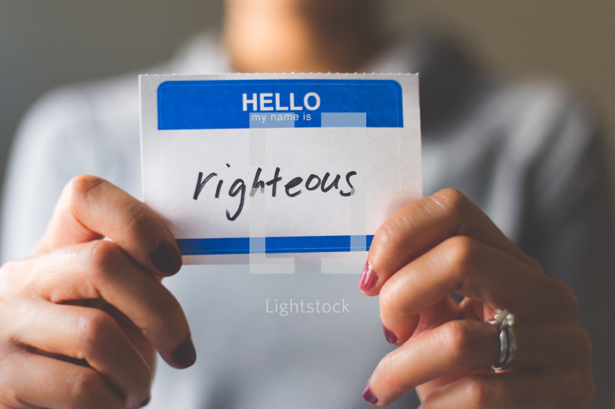 woman holding a name tag with the word righteous 