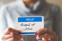 woman holding a name tag with the word friend of Jesus 