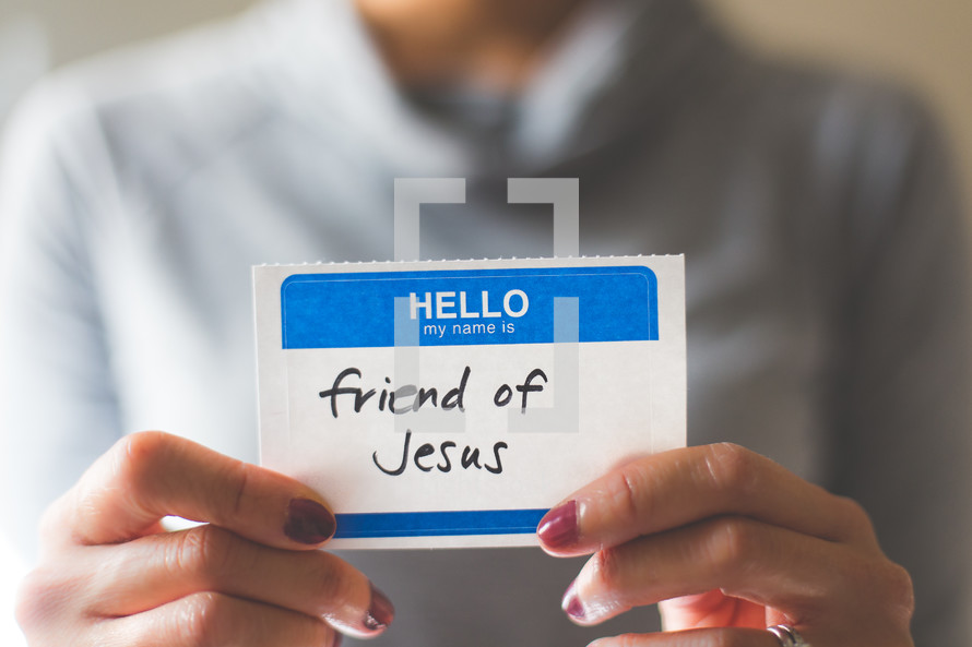 woman holding a name tag with the word friend of Jesus 