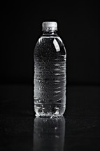 A refreshing bottle of water on black seamless