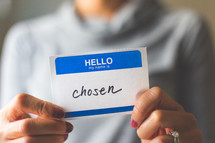man holding a name tag with the word chosen 