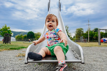 infant sitting on a slide 