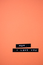 A label reading, "Mom, I love you," on an orange background.