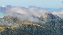 Time lapse of clouds over green mountains in Tararua forest park in New Zealand.
