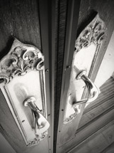 angled photo of shiny door handles in black and white