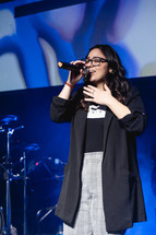 a young woman singing on stage 