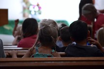children listening sitting in church pews 