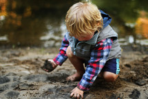 boy child playing in mud 