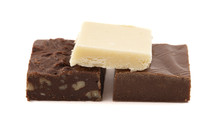 Chocolate fudge dessert squares on white background
