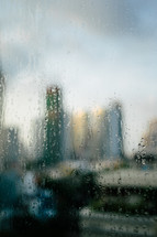 view of a city through a blurred wet and foggy window 